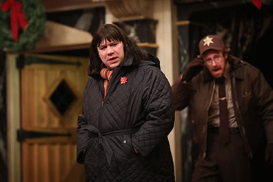 Production photo of Janice in black coat with Sherrif Boyd Sanning behind her.